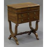 An early 19th century French cherry wood work table, the hinged lid above two frieze drawers, raised