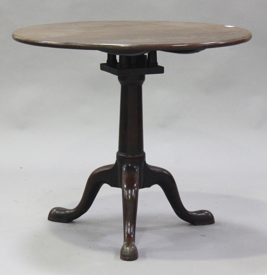 A George III mahogany circular tip-top wine table with bird cage mount, raised on a turned