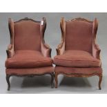 A pair of 20th century French walnut wingback showframe armchairs, upholstered in pink velour, on