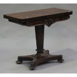 An early Victorian figured mahogany fold-over card table, the hinged top above a carved foliate