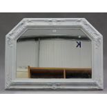 A modern white painted overmantel wall mirror with moulded leaf scroll decoration, 87cm x 114cm.