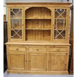 A late 20th century pine kitchen dresser, the top fitted with central shelves flanked by glazed