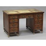 An Edwardian oak twin pedestal desk, the moulded top inset with a tan leather writing surface and