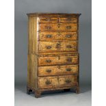 A George I walnut chest-on-chest with crossbanded decoration, the moulded pediment above two short
