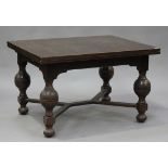 A George V oak draw-leaf dining table, raised on bulbous supports united by stretchers, height 76cm,