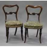 A set of eight early Victorian rosewood spoon back dining chairs with carved foliate centre rails