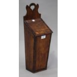 A late George III oak candle box with mahogany crossbanded borders and a sloping hinged lid,