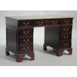 A late 20th century reproduction mahogany twin pedestal desk, fitted with an arrangement of eight