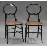 A pair of Victorian black lacquered bedroom chairs with gilded and mother-of-pearl inlaid