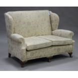 An early 20th century Queen Anne style two-seat settee, upholstered in foliate patterned fabric,