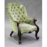 A mid-Victorian mahogany buttoned back salon armchair, upholstered in green velour, the carved