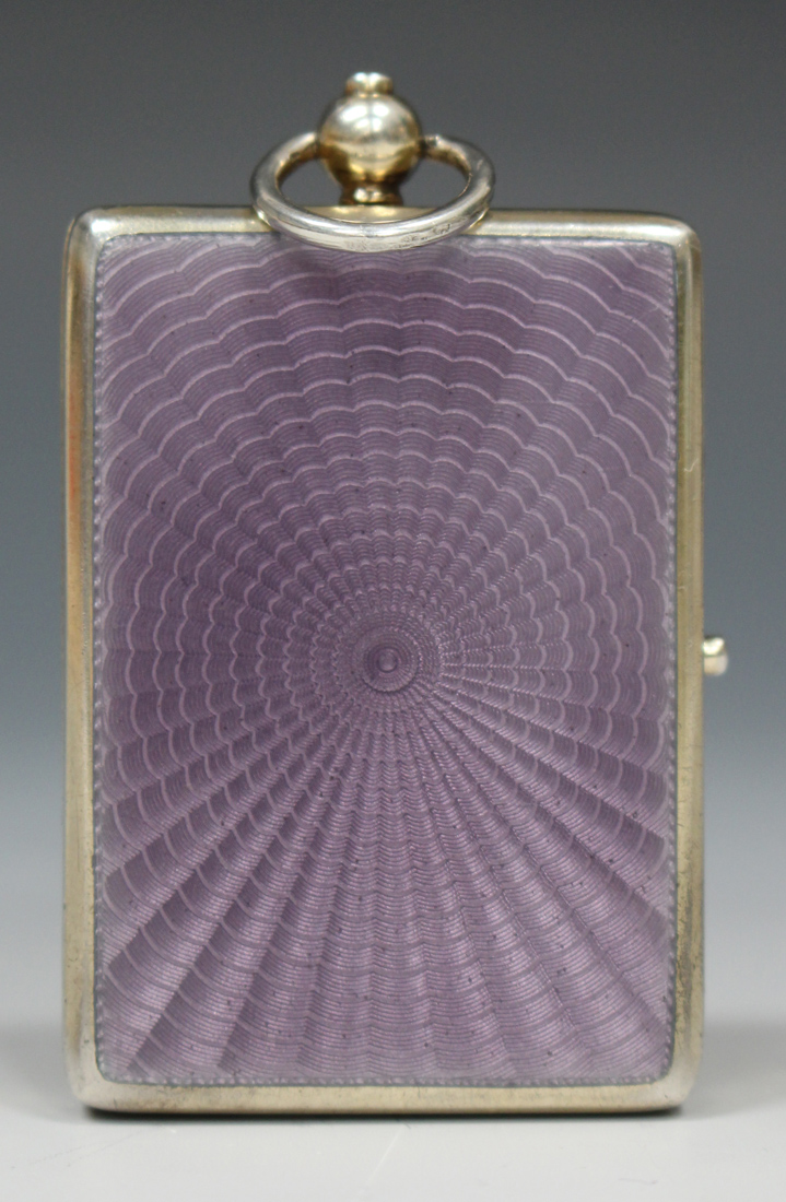 A George V silver gilt and lilac enamel rectangular compact, hinged to reveal a mirror and oval