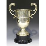 A George V silver trophy cup, the girdled 'U' shaped body flanked by flying scroll handles, raised