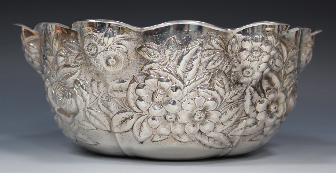 An early 20th century American sterling bowl of lobed form with wavy rim, decorated in relief with