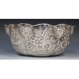 An early 20th century American sterling bowl of lobed form with wavy rim, decorated in relief with