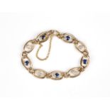 A gold, diamond and sapphire curblink bracelet, collet set with four cushion shaped diamonds