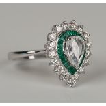 An 18ct white gold, emerald and diamond oval cluster ring, claw set with a pear shaped diamond