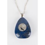 A moonstone and blue stained jasper drop shaped pendant, the front mounted with a circular motif,