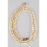 A two row necklace of graduated cultured pearls on a white gold, platinum, sapphire and diamond