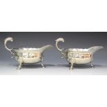 A pair of George II silver sauce boats, each with foliate capped flying scroll handle, on scallop
