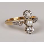 A gold, diamond and pearl ring, mounted with the single pearl between two principal cushion shaped