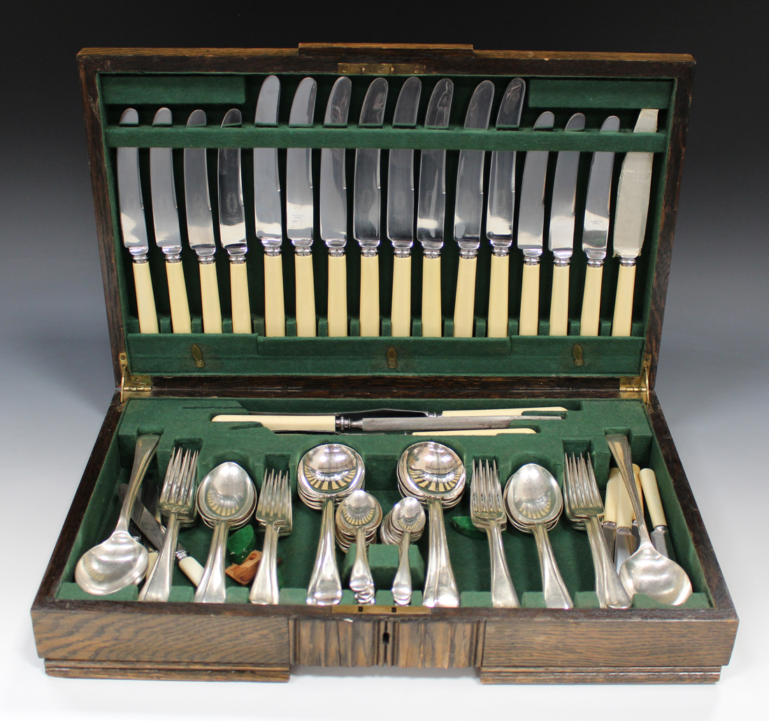 A George V plated part canteen of cutlery, comprising eight table knives and forks, four