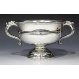 A George V silver two handled trophy cup, the circular body flanked by a pair of foliate capped