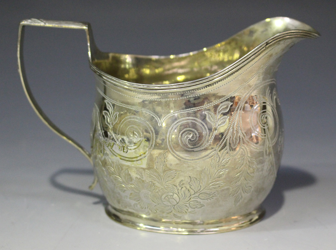 A George IV silver cream jug of oval form with angular ribbon and reeded handle, engraved with