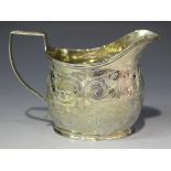 A George IV silver cream jug of oval form with angular ribbon and reeded handle, engraved with