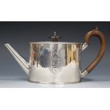 A George III silver oval teapot, engraved with an oval cartouche and shield shaped crest, the banner