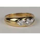 An 18ct gold and diamond three stone ring, gypsy set with a row of circular cut diamonds with the