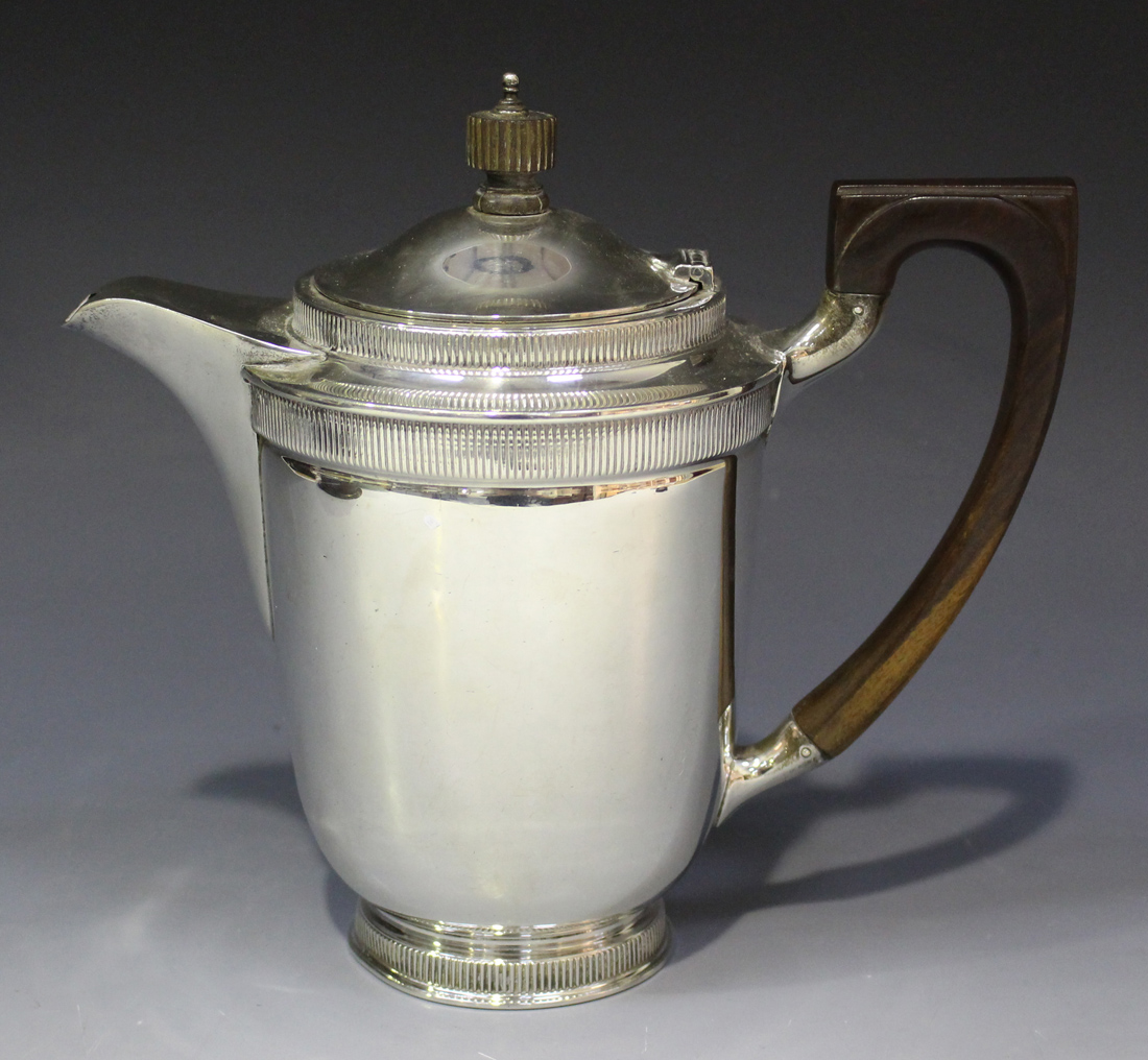 A George V silver coffee pot of 'U' shaped form with domed lid, decorated with vertical reeded