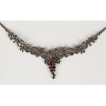 A silver, garnet and marcasite necklace, the front of scrolling fruiting vine form mounted with