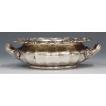 A Victorian silver circular dish of squat lobed form, the outswept rim cast with stylized scallop