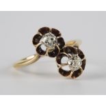 A gold and diamond set two stone ring, claw set with cushion shaped diamonds in flowerhead shape