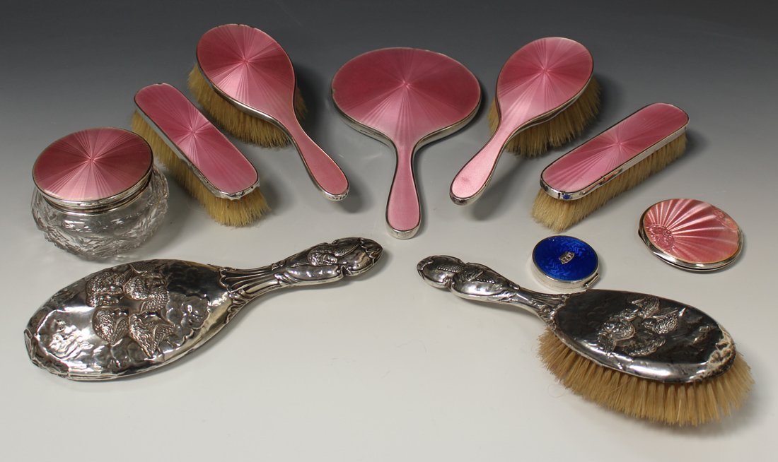 A George V silver and pink enamel six piece dressing table set, comprising two hairbrushes,