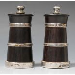 A pair of silver mounted turned hardwood pepper mills, each of tapering cylindrical form with banded