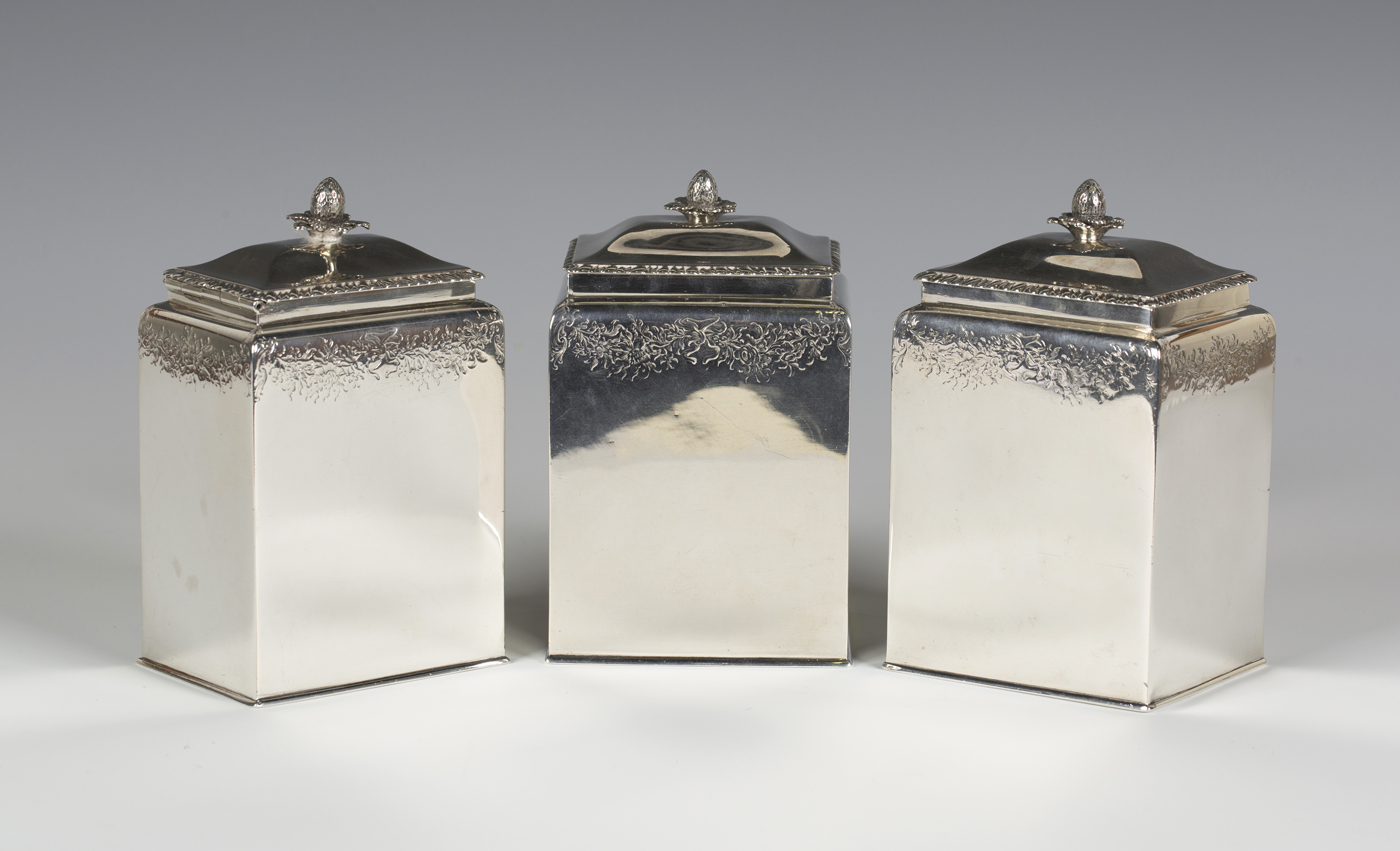 A set of three George III silver graduated tea caddies of rectangular form, each cover with flower