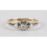 A gold and platinum, diamond set single stone ring, mounted with a circular cut diamond between