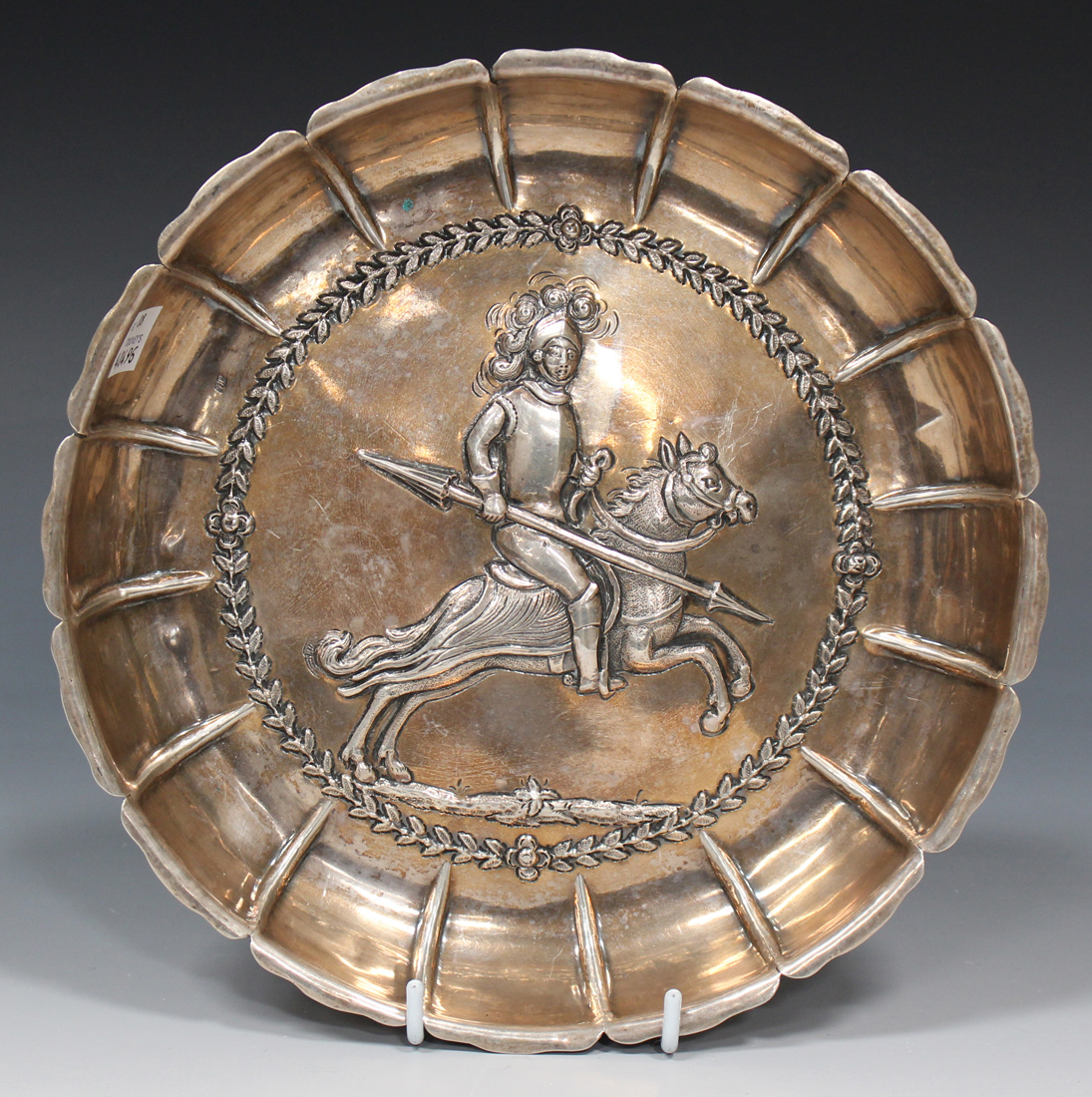 A Continental silver circular dish with pinched rim, the centre decorated in relief with a