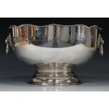 A 20th century plated punch bowl with serpentine shaped rim, flanked by two lion mask ring