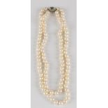 A two row necklace of uniform cultured pearls on a diamond and aquamarine set oval clasp, length