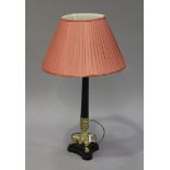 A late 20th century black and gilt painted cast composition table lamp with a reeded stem and