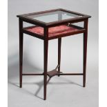 An Edwardian mahogany bijouterie table, the glazed top and sides raised on square tapering legs