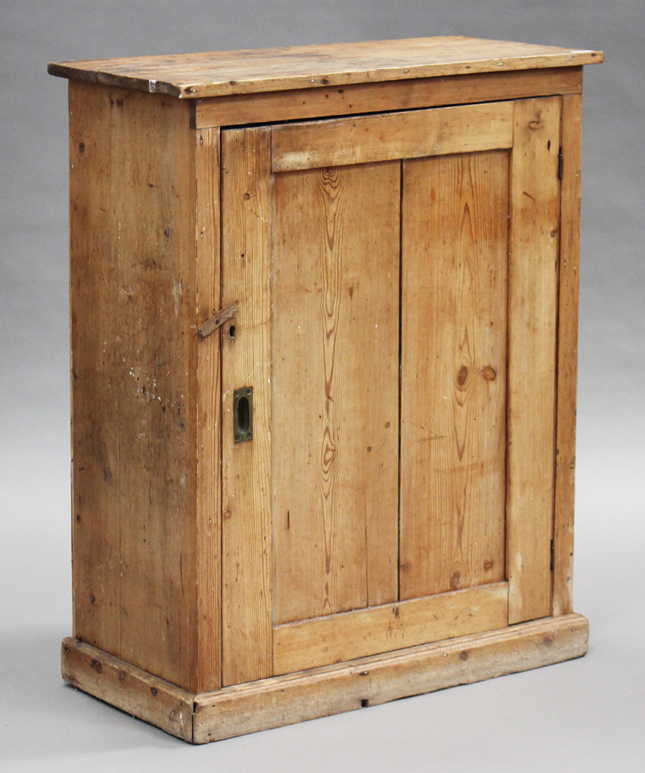 A 20th century stripped pine side cabinet, fitted with a panel door, on a plinth base, height 107cm,