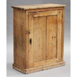 A 20th century stripped pine side cabinet, fitted with a panel door, on a plinth base, height 107cm,