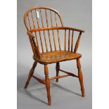 A mid-19th century provincial ash and elm hoop and spindle back Windsor armchair, the solid seat