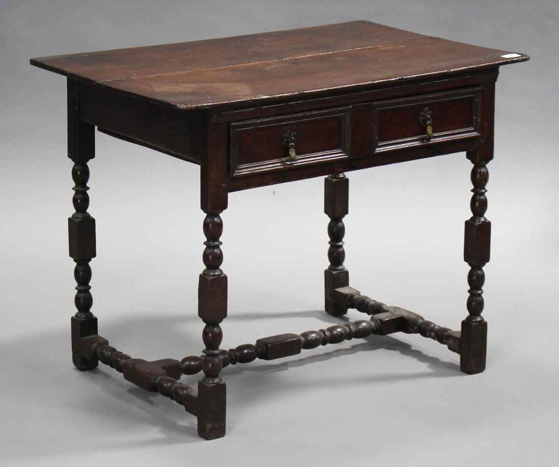 An early 18th century and later oak lowboy, fitted with two frieze drawers, raised on turned and