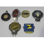 A small collection of car badges, including a Royal Automobilia Club Associate member's badge,