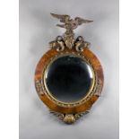 A mid-Victorian figured mahogany and giltwood circular convex wall mirror, the carved eagle, dolphin